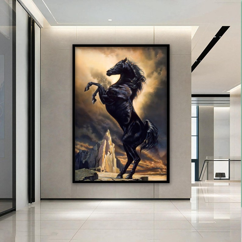 May include: A black horse rearing up on its hind legs against a dramatic backdrop of clouds and a rocky mountain. The horse's mane and tail flow in the wind, creating a sense of power and freedom.