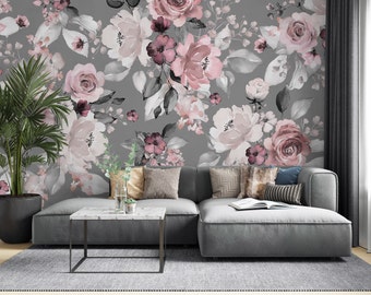May include: A gray couch with pillows sits in front of a wall with a floral wallpaper pattern. The wallpaper features pink and gray flowers with a watercolor effect.
