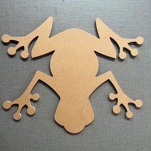 May include: A wooden cutout of a frog in a brown colour. The frog is facing upwards with its legs spread out.