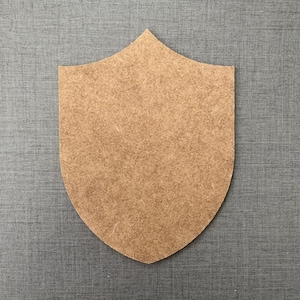 May include: A brown wooden shield shape, ideal for crafting and DIY projects.
