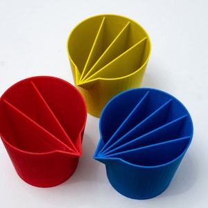 May include: Three colorful plastic cups with divided sections. The cups are yellow, red, and blue.