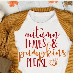 May include: White t-shirt with the text "autumn leaves & pumpkins please" in red and orange lettering. A small orange pumpkin graphic is below the text.