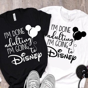 May include: Two black and white t-shirts with a Mickey Mouse graphic and the text "I'm done adulting I'm going to Disney".