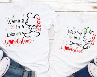 May include: Two white t-shirts with a black and white silhouette of Mickey Mouse and Minnie Mouse. The shirts have the text "Walking in a Disney Wonderland" and the year "2022" printed on them.