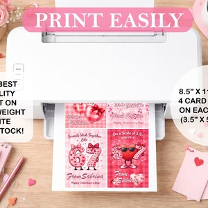 May include: A white printer printing Valentine's Day cards. The cards are printed on 8.5" x 11" paper, with four 3.5" x 5" cards per sheet. The cards feature hearts and the text "From Sabrina".