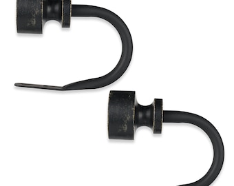 May include: Two black metal curtain rod finials with a distressed finish. Each finial has a round top and a small, cylindrical base.