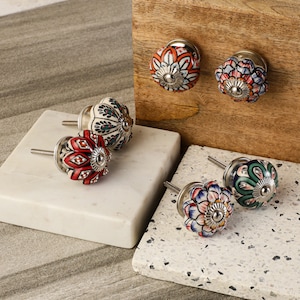 May include: Assortment of colorful ceramic cabinet knobs with floral patterns. Each knob features a different design with a silver metal base and screw.