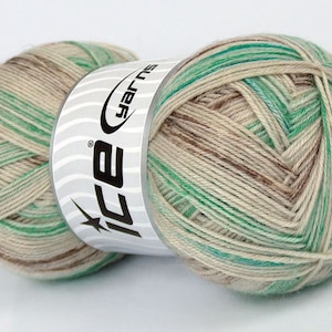 May include: A skein of yarn in a beige, brown, and green colorway. The yarn is wrapped around a white label with the text "ICE yarns" printed in black.