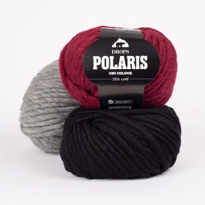 May include: Three balls of yarn in red, gray, and black. The red ball has a label that reads "DROPS POLARIS UNI COLOUR 100% wool".
