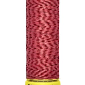 May include: A spool of red Gütermann thread. The thread is tightly wound on a cylindrical spool with a yellow base and top. The top of the spool has the Gütermann logo in black. The base of the spool has the text "50 m - 55 yds/vgs".