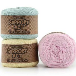 May include: Three skeins of yarn in pastel colors. Two are stacked, wrapped with brown labels that read "SUPPORT ACT The Blended One." The third is a loose ball of pink yarn. Ideal for knitting and crochet projects.