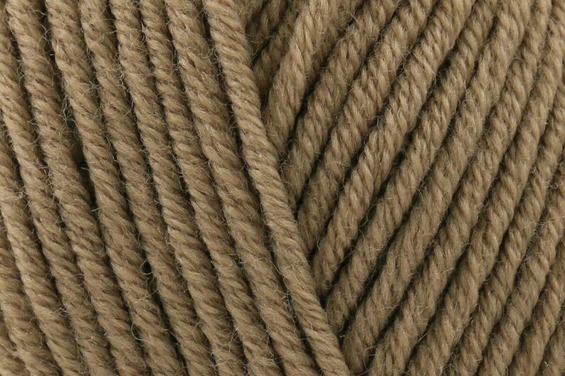 May include: A close-up view of light brown yarn featuring a multi-ply twisted construction. The individual strands are tightly wound together, creating a consistent diagonal texture across the entire surface of the fiber bundle.