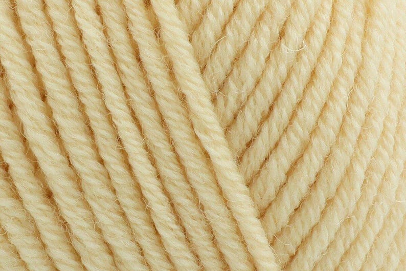May include: A close-up view of cream-colored yarn, showcasing the twisted fiber construction and the soft, matte texture of the individual strands. The threads are arranged in parallel lines, highlighting the consistent ply and natural off-white hue.