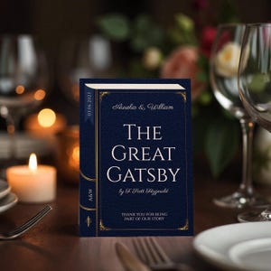 Könnte beinhalten: Eine blaue und goldene Hochzeitseinladung mit dem Text "The Great Gatsby" von F. Scott Fitzgerald. Die Einladung ist mit einem goldenen Rand und einem goldenen Band verziert. Der Text "Aurelia & William" und das Datum "03.06.2023" sind ebenfalls enthalten.