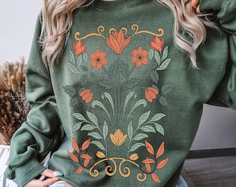 May include: A green sweatshirt with a floral design featuring orange, yellow, and red flowers. The text "Military Green" is printed on the bottom of the sweatshirt.