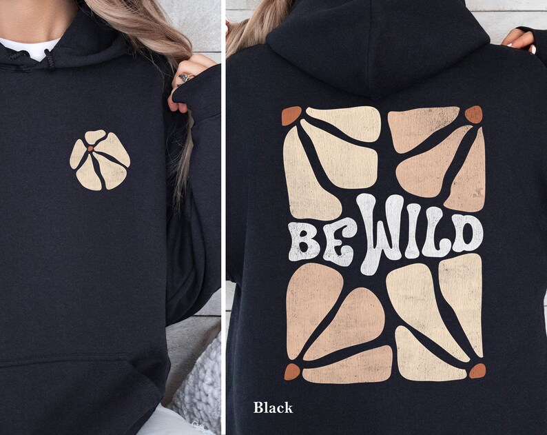 Op de afbeelding: Zwarte hoodie met een grafische print van een geometrisch ontwerp en de tekst "BE WILD" in wit.