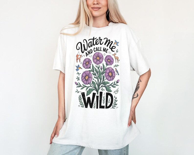 May include: White t-shirt with a floral design and the text "Water me and call me wild".