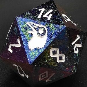 Könnte beinhalten: Ein schwarzer und schillernder W20-Würfel mit weißen Zahlen und einem weißen Raben-Symbol. Die Zahlen auf dem Würfel sind 1, 2, 3, 4, 5, 6, 7, 8, 9, 10, 11, 12, 13, 14, 15, 16, 17, 18, 19 und 20.