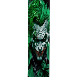 Op de afbeelding: Een groene en zwarte afbeelding van de Joker uit Batman. De Joker glimlacht met een sinistere grijns en heeft groen haar. De achtergrond is zwart met groene spetters.