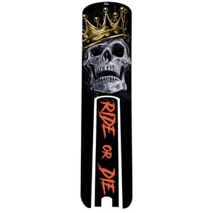 May include: Black and white skull graphic with a gold crown on top. The skull is wearing a crown and the text "RIDE OR DIE" is written in red on a black background.