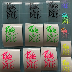 Könnte beinhalten: Eine Sammlung von Vinyl-Aufklebern mit dem Schriftzug "Ride or Die" in verschiedenen Farben wie Schwarz, Grün, Pink und Gelb. Die Aufkleber befinden sich auf einer Schneidematte. Der Text ist in einer stilisierten Schriftart gehalten.
