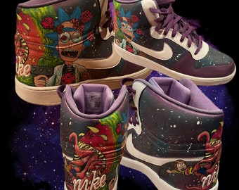 May include: A pair of high-top sneakers with a galaxy-themed design. One shoe features a cartoon character with green hair and a red shirt, while the other shoe features a cartoon monster with red eyes and sharp teeth. The shoes are purple and white with the word "Nike" written on the side.