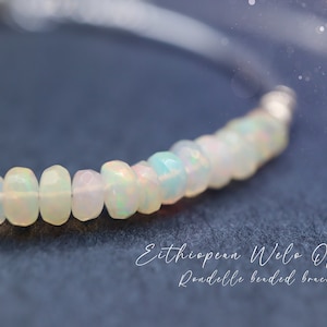 May include: A delicate bracelet made with white Ethiopian Welo Opal rondelles. The bracelet is strung on a clear thread and has a silver clasp.