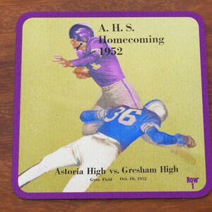 May include: Vintage square coaster with a purple border featuring a football game illustration. The text reads "A.H.S. Homecoming 1952" and "Astoria High vs. Gresham High, Oct. 10, 1952."