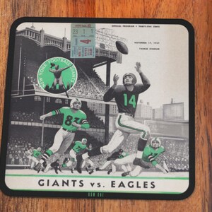 May include: A vintage black and white photo of a football game between the New York Giants and the Philadelphia Eagles. The photo is from November 10, 1947, at the Polo Grounds Stadium. The Giants logo is in the top left corner of the photo. The text "Giants vs. Eagles" is at the bottom of the photo.