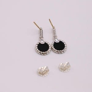 Puede incluir: Un par de pendientes de plata con piedras de &oacute;nix negro y un dise&ntilde;o de cuerda trenzada. Los pendientes son de estilo colgante y tienen un cierre de poste.