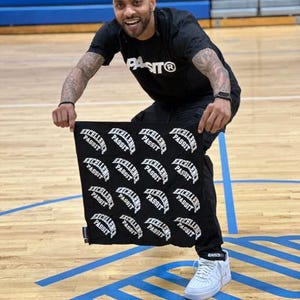 May include: A man wearing a black t-shirt with the word "PASIT®" printed on it, holds a black bandana with the words "EXCELLENCE PASSIT" repeated in white.