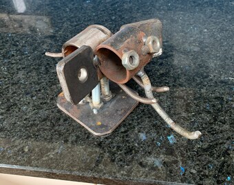 May include: A metal sculpture of a dog made from recycled metal parts, including pipes, nuts, and bolts. The sculpture is painted in a metallic silver color and has a rustic, industrial look.