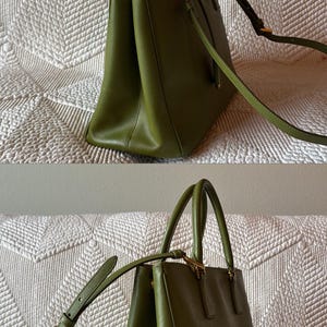 May include: Olive green handbag with top handles and a detachable shoulder strap. The bag features gold-tone hardware and a structured design. The bag is made of a smooth material and has a rectangular shape.