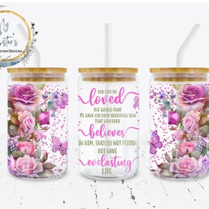 May include: Three clear glass tumblers with bamboo lids and pink floral designs. The tumblers have straws and feature the text "For God so loved the world that he gave his only begotten son that whoever believes in him, should not perish but have everlasting life."