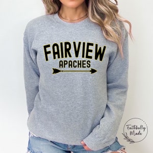 May include: Gray sweatshirt with black text that reads "FAIRVIEW APACHES" with a yellow outline. A black arrow with yellow outline is below the text.