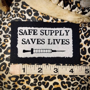 Safe supply saves lives. sew on punk patch for progressive battle vests, crusty leftist overalls, backpacks