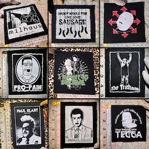 May include: A selection of black fabric patches with printed designs and text. The patches display images and phrases including "Milhaus," "Daddy Would You Like Some Sausage," "Pro-Pain," and "I Want to Believe." The patches are of various sizes.
