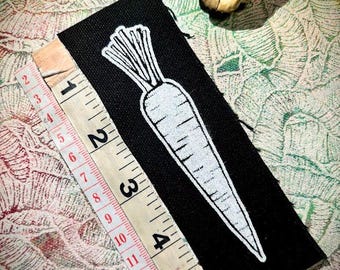 Es un parche punk de zanahoria para coser.