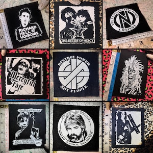 May include: A collection of nine square black and white fabric patches featuring various band logos and graphics, including Richard Hell and the Voidoids, The Sisters of Mercy, Conflict, Mercyful Fate, Crass, Chumbawamba, and The Adverts.