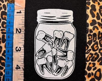 Un frasco de dientes, parche dental punk
