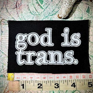 Parche punk para coser con la frase "Dios es trans"