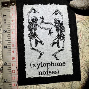 Dansende skeletten maken xylofoongeluiden | punkpatch | spookachtige gevechtsvesten | jacks met horrorkorst | Witchy gothic-rugzakken | klassieke tekenfilms