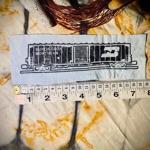 May include: Black and white illustration of a train car with the text "BURLINGTON NORTHERN" and "BN" on the side. The car is labeled with the number "55149".