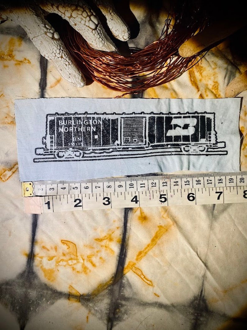 May include: Black and white illustration of a train car with the text "BURLINGTON NORTHERN" and "BN" on the side. The car is labeled with the number "55149".