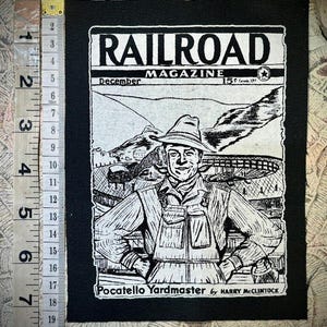 May include: Black and white patch featuring a vintage "Railroad Magazine" cover illustration. The image shows a smiling man in work attire, with text including "December" and "Pocatello Yardmaster". The patch measures approximately 4 inches by 3 inches.