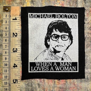 May include: Black and white iron-on patch featuring a portrait of Michael Bolton and the text "When a Man Loves a Woman".