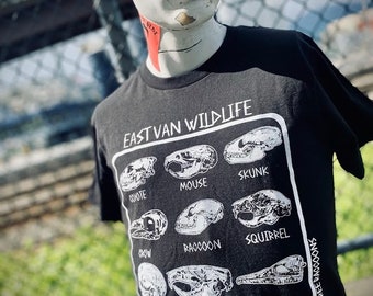 May include: Black t-shirt with a white graphic of animal skulls and the text "East Van Wildlife" and "Three Raccoons".