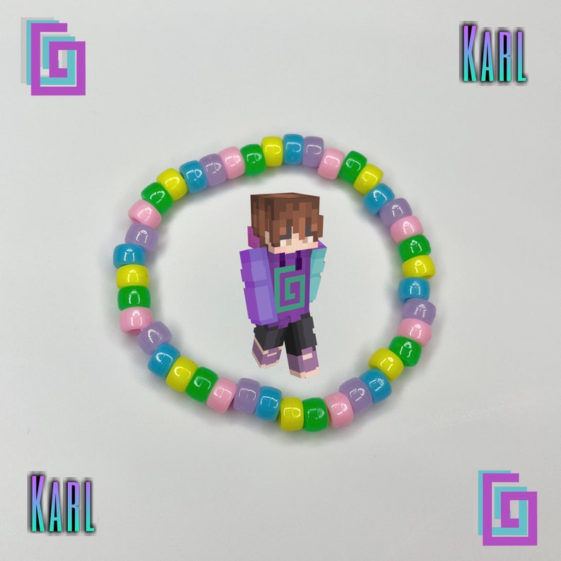 May include: A colorful beaded bracelet with pink, yellow, green, and blue beads. The bracelet is in the shape of a circle and is lying flat on a white surface. The word "KARL" is written in black letters on the surface.