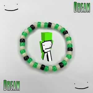 May include: Green, white, and black beaded bracelet with the word "DREAM" on either side of the image. A green Minecraft character is in the center of the bracelet.