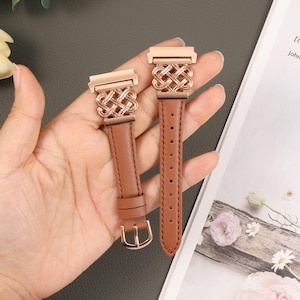 Puede incluir: Dos correas de reloj de cuero marr&oacute;n con cierres de metal dorado rosa y un dise&ntilde;o tejido. Las correas se muestran en una mano.